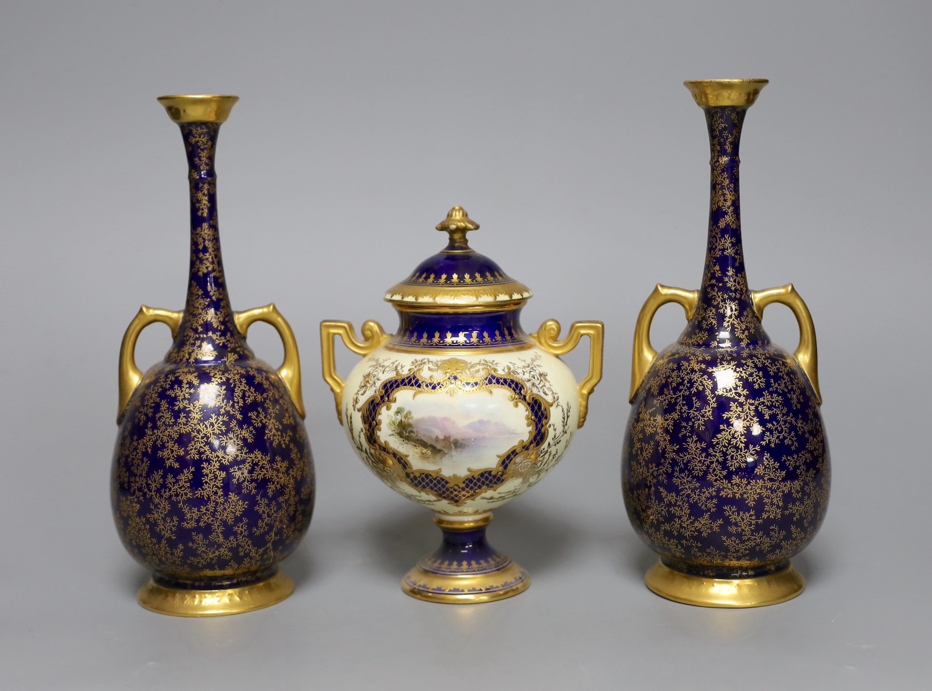 A pair of Royal Worcester bottle vases and a Coalport landscape vignette vase and cover, pair of vases 20 cms high
